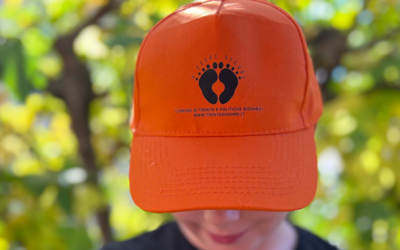 Un bambino con il cappellino arancione del progetto "A Piedi Sicuri"