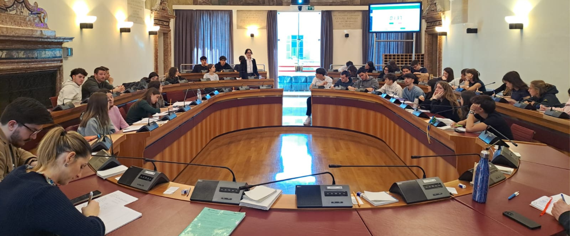 Dei ragazzi e delle ragazze nella sala del Consiglio comunale di Trento