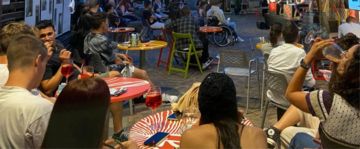 Ragazzi e ragazze seduti a dei tavolini di un bar