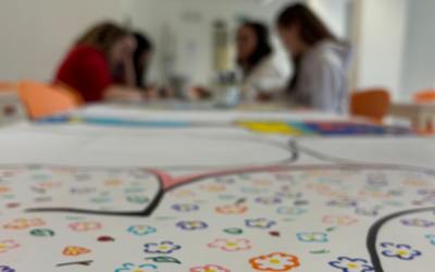 un cartellone pieno di fiori disegnati e sullo sfondo delle ragazze 