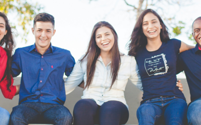 Tre ragazze e due ragazzi seduti insieme