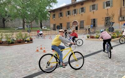 un gruppo di ragazzini in bicicletta compie un percorso segnato da birilli