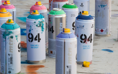 Bombolette spray per dipingere, appoggiate per terra.