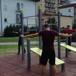 alcuni ragazzi stanno facendo esercizi in una palestra calesthenics in un parco cittadino 