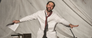 un attore che recita con le braccia aperte