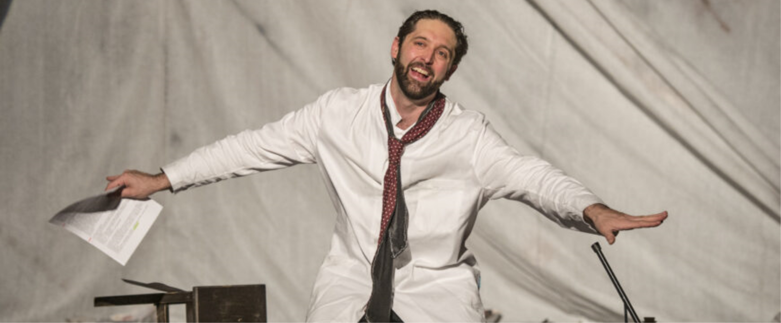 un attore che recita con le braccia aperte