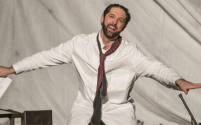 un attore che recita con le braccia aperte