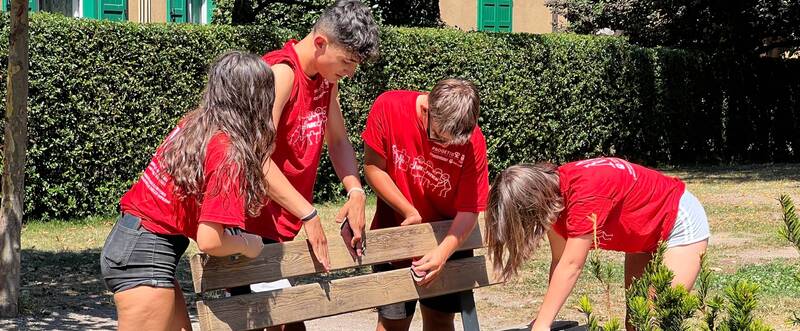 Quattro giovani intenti restaurare una panchina