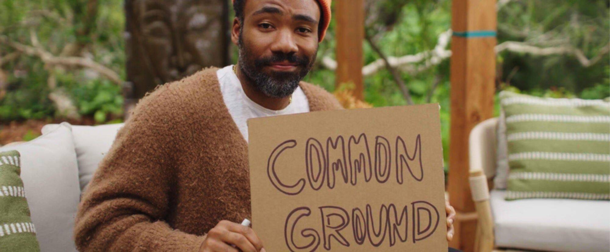 Ragazzo teine in mano un cartone con la scritta "Common ground"