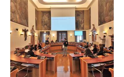 alcuni ragazzi e ragazze seduti all'interno della sala del consiglio comunale