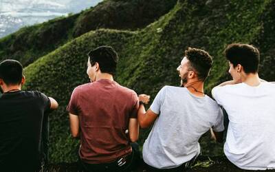 Quattro ragazzi seduti sul sentiero di montagna