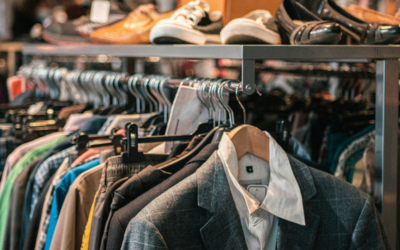 Uno scaffale di vestiti e scarpe in un negozio dell'usato