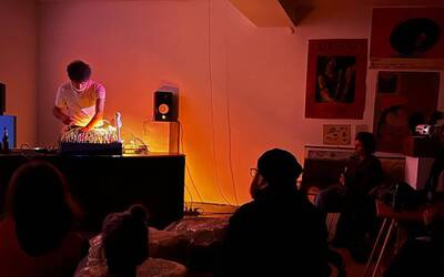 stanza al buio, un ragazzo sta suonando musica elettronica e gli altri lo ascoltano