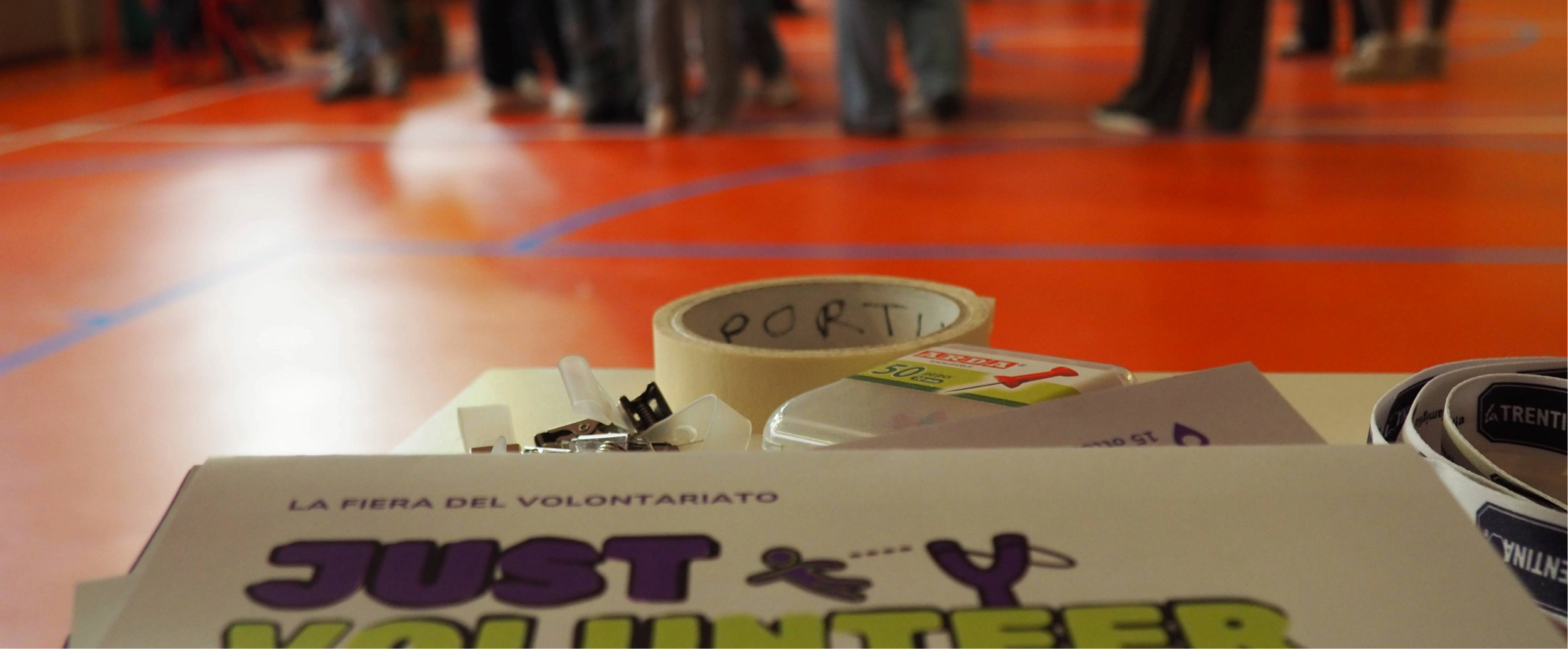 un volantino in primo piano sullo sfondo una palestra e delle persone