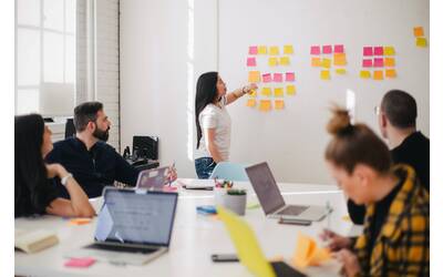 donna che appende post it al muro 