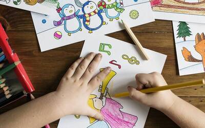 immagine di due mani piccole che colorano dei disegni per bambini