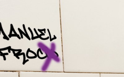 una scritta offensiva sul muro di un bagno 