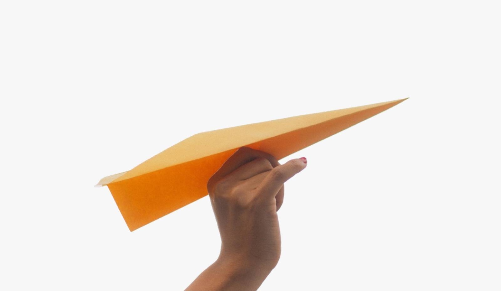 Una mano che lancia un aereoplanino di carta arancione