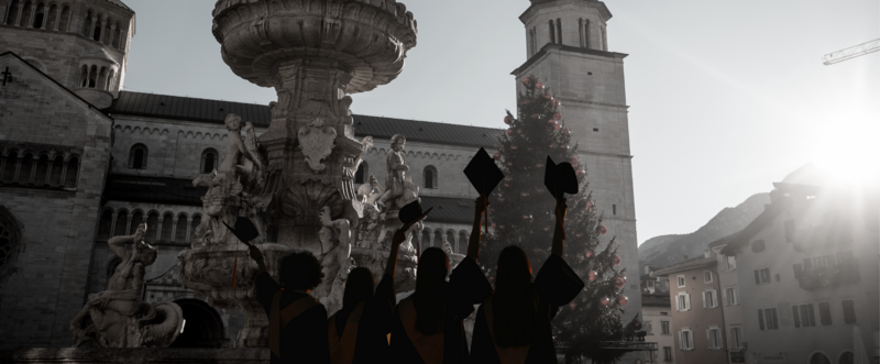 Dei ragazzi con il cappello del diploma in piazza Duomo a Trento