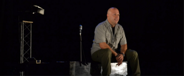 L'attore MArio Cagol al centro di un palco buio