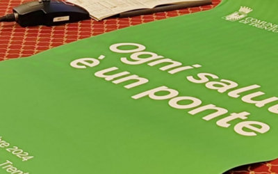 Un poster verde con lo slogan dell'iniziativa sul tavolo della conferenza stampa del Comune di Trento