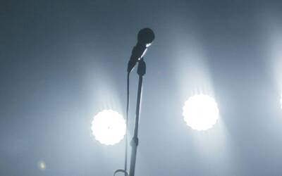 Un microfono sull'asta e uno sfondo di luci 