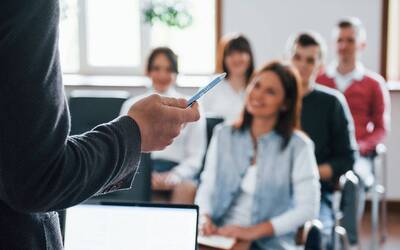 Persone che ascoltano un'altra persona che tiene una lezione.