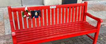 Una panchina rossa con l'immagine di Agitu