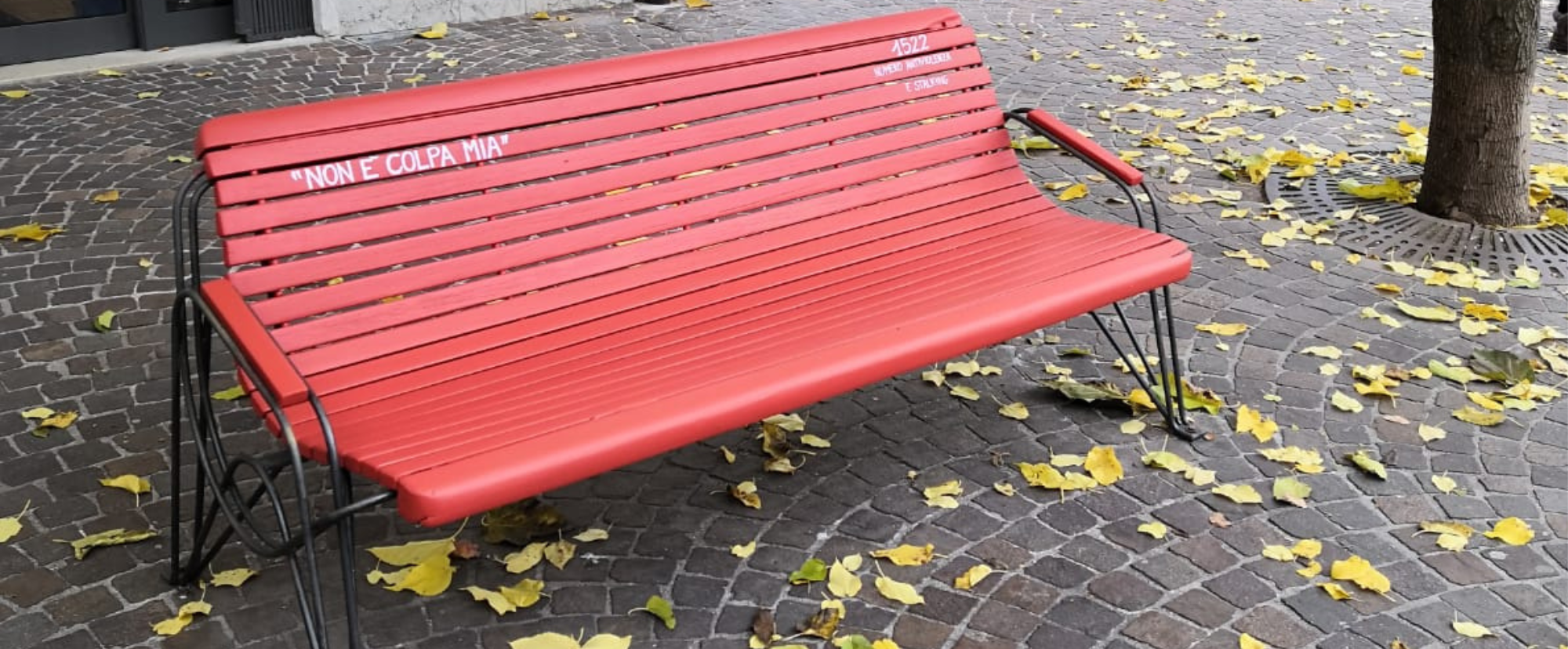una panchina rossa sul bordo di una strada