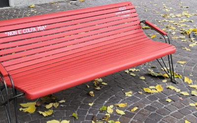 una panchina rossa sul bordo di una strada