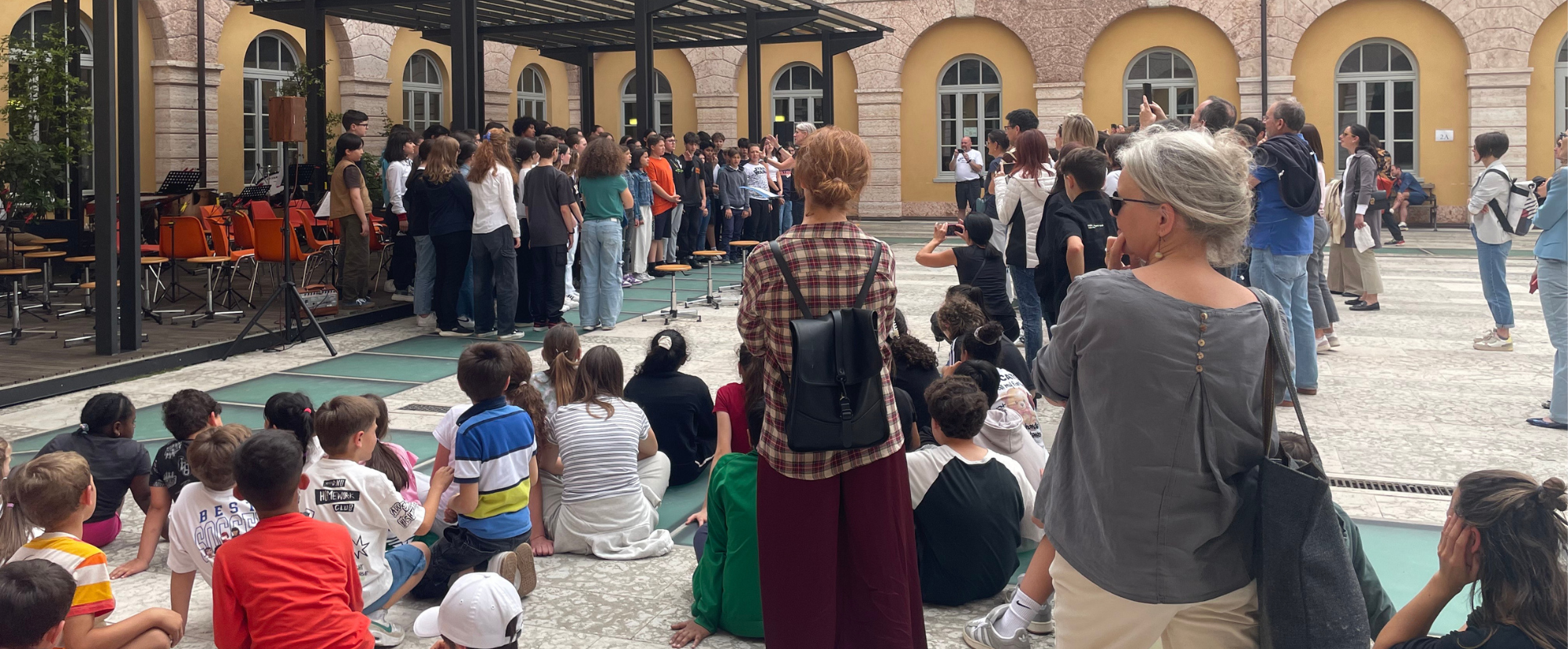 Adulti e bambini all'interno di un cortile scolastico