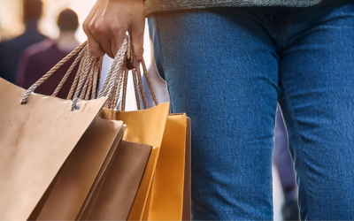 particolare di una persona che cammina con delle buste di negozi