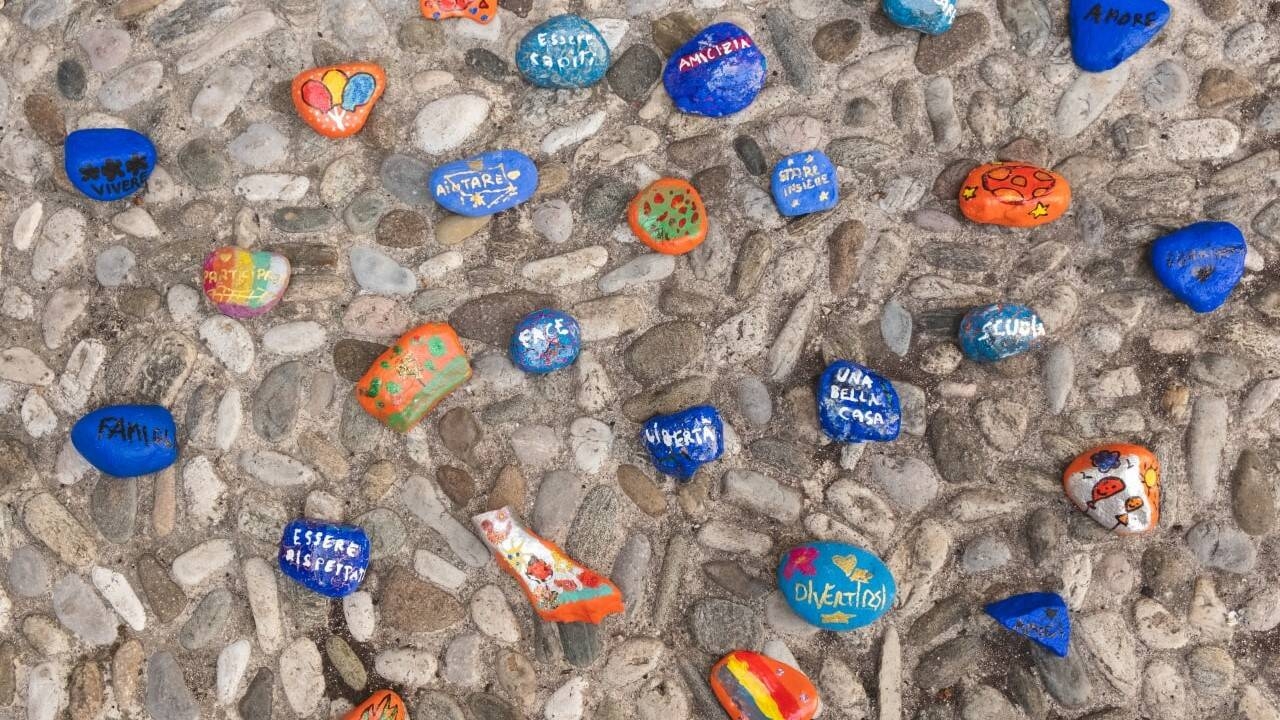 sassi dipinti con vari colori con scritte riportanti i desideri dei bambini