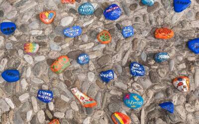 sassi dipinti con vari colori con scritte riportanti i desideri dei bambini