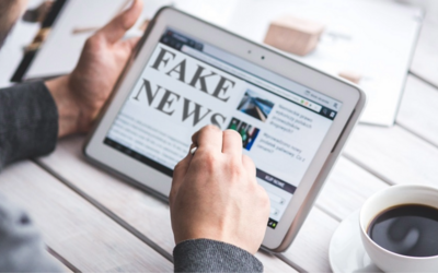giovane di schiena che naviga su un tablet dove si parla di fake news