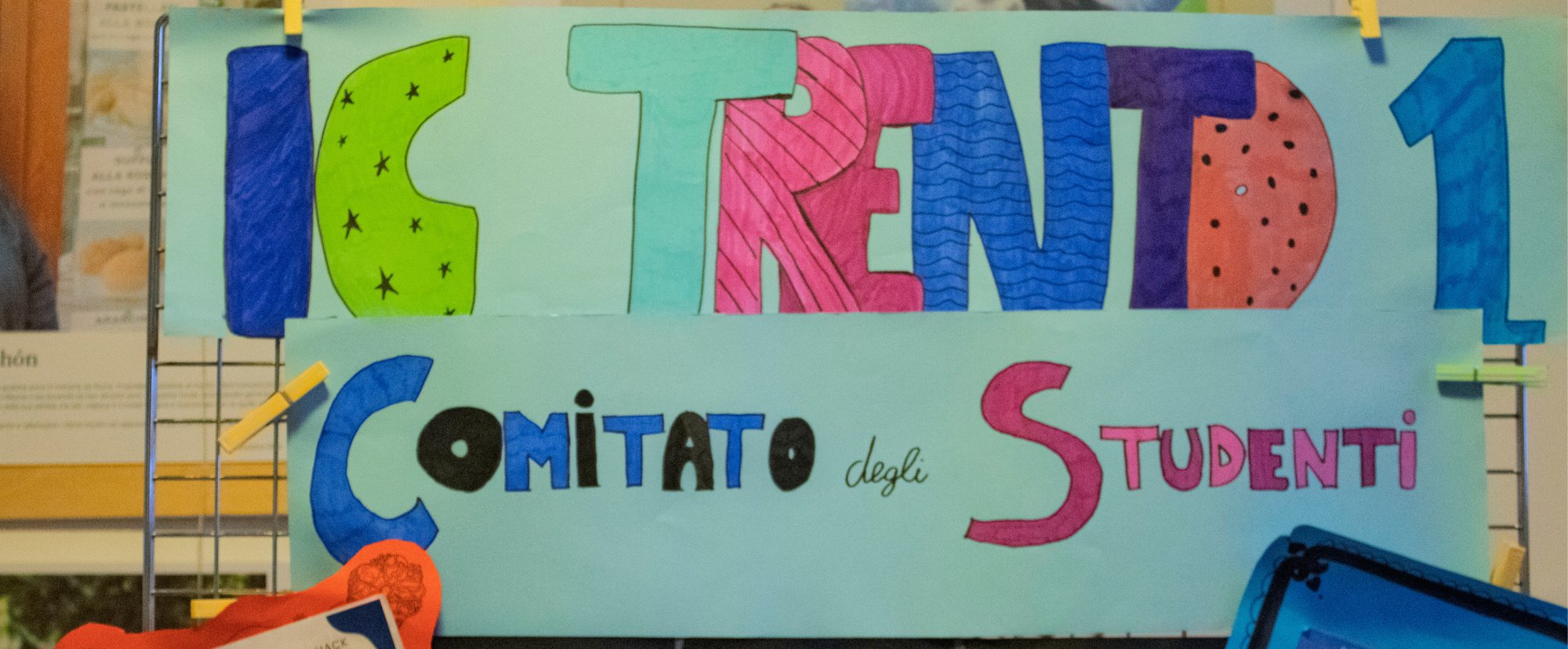 Un cartellone azzurro con la scritta colorata "IC Trento 1"