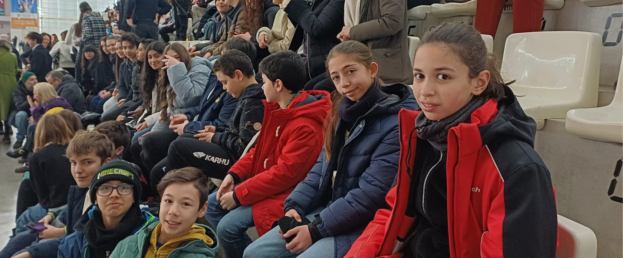 un gruppo di bambini e bambine sulla scalinata del palazzetto dello sport di trento