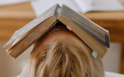 Un ragazzo a testa in su, visto da dietro, con un libro in faccia