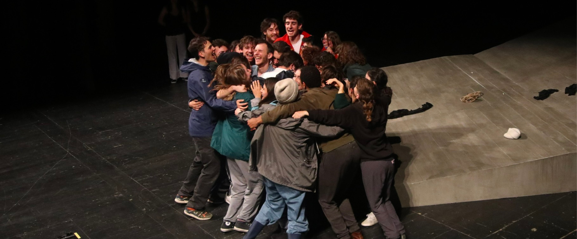 Ragazzi che si abbracciano su un palco teatrale.