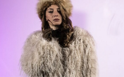 Una donna con un cappello di pelliccia su uno sfondo rosa