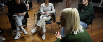 Una persona che racconta ad un cerchio di giovani